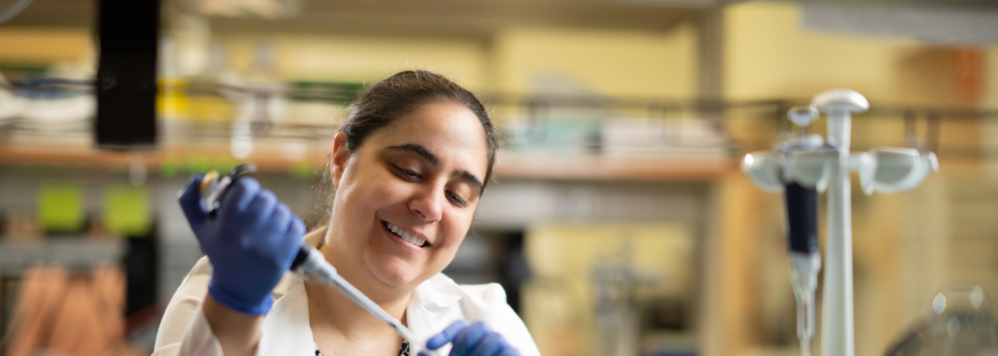 Dr. Marina Sharifi in a lab with a pipette
