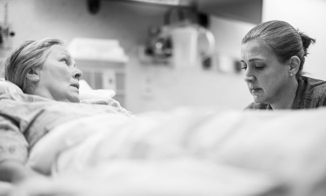 In one of the year’s final simulations, fellow Elizabeth Sullivan, MD, must manage the acute pain crisis of a terminal patient (left) who is also experiencing spiritual distress. Actor Karen Moeller plays the patient. Credit: Clint Thayer/Department of Medicine.