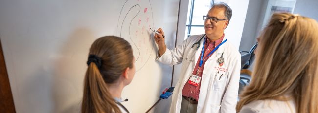 Sameer Mathur drawing on a whiteboard and teaching