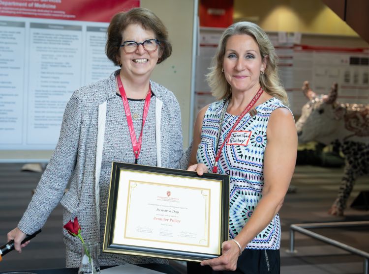 Dr. Lynn Schnapp and Jennifer Pulley pose with an award for Jennifer.