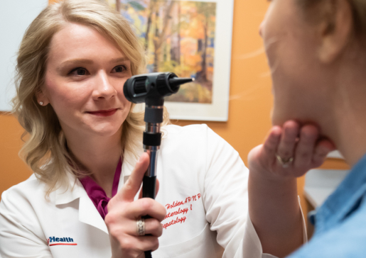 A gastroenterology nurse practitioner examines a patient's mouth and throat in the clinic