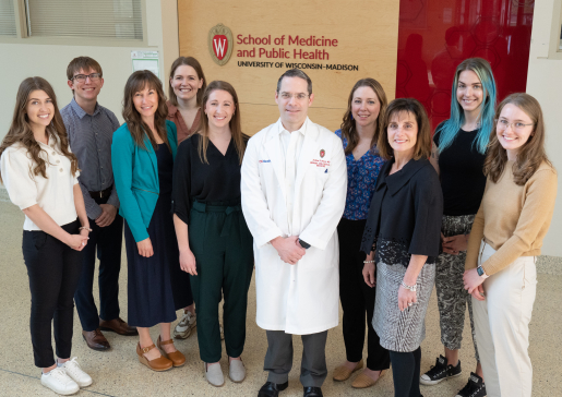 Group photo of Dr. Andrew Braun and the cystic fibrosis team in a hallway at the Wisconsin Insitutes for Medical Research