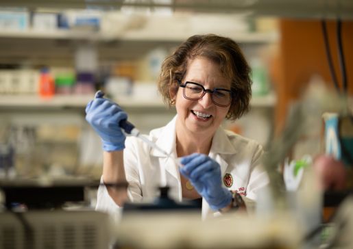Dr. Lynn Schnapp wearing white coat working in the lab
