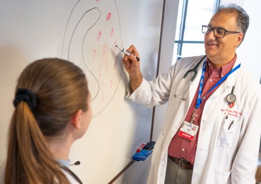 Sameer Mathur drawing on a whiteboard and teaching